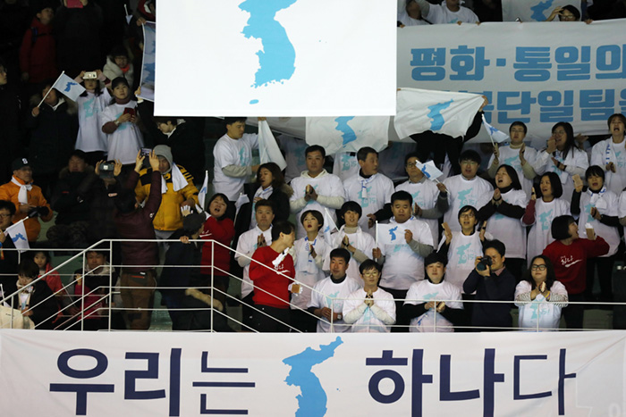남북 여자아이스하키 단일팀이 스웨덴과 평가전을 치른 4일 ‘우리는 하나다’라고 적힌 팻말이 걸린 관중석에서 응원단이 한반도기를 흔들고 있다.